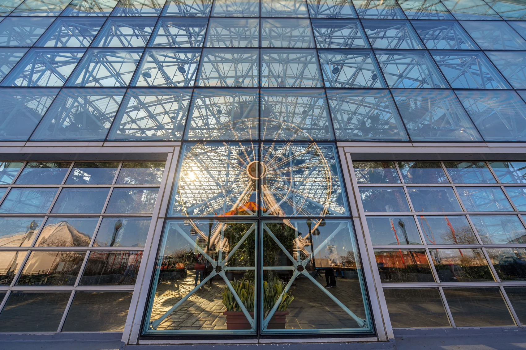 Reflection of Navy Pier Centennial Wheel in glass windows showcasing urban architecture by a commercial glass company. storefront vs curtain wall
